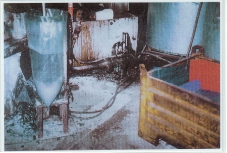 Dieses Bild, ebenfalls aus der Halle 1 aus dem Jahr 1998, zeigt die angeblich geschlossenen Arbeitsabläufe bei Pelzer, wonach gar keine giftigen Substanzen austreten oder eingeatmet werden konnten. Diese Angaben vor Gericht und gegenüber der BG sind wie man sieht, nachweislich falsch! Oben schaut das Rührwerk aus dem Sack, dieser hatte des Öfteren undichte Stellen, so dass der gesamte Boden kontaminiert war. Da wurde reingetreten, das wurde auch mit nach Hause genommen. Die dort Arbeitenden bezahlten mit ihrem Leben und ihrer Gesundheit. Und das alles aus reiner Profitgier. Diese Bilder wurden allen Aufsichtsbehören vorgelegt, alle haben die Augen zugedrückt.